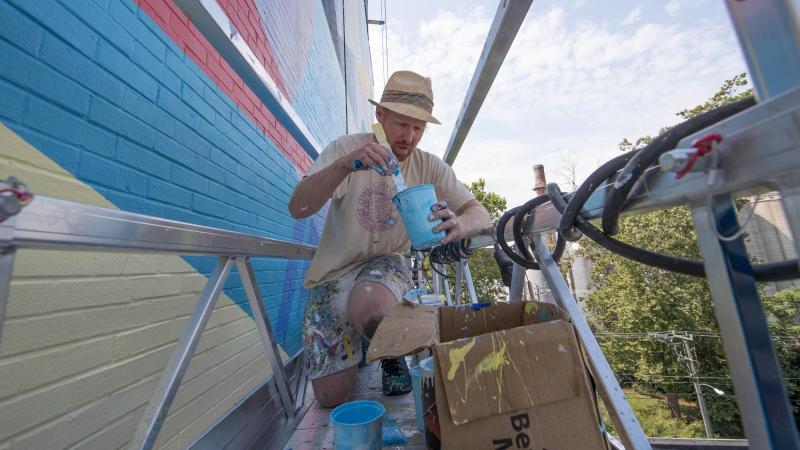Guinn, pictured above, has painted more than 35 murals around the world, including several in his hometown of Philadelphia and works in Amman, Jordan; Montreal; Chicago; Washington, D.C.; and New York. This is his first mural in Charlottesville.