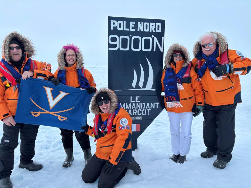 Five travelers on a UVA-sponsored cruise to the North Pole pose in the Arctic with a UVA flag.