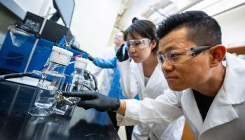 Students Liyue Zhang and Shen-Wei Yu, foreground, lean in for a closer look in a UVA lab aiming to make hydrogen energy a viable alternative. 