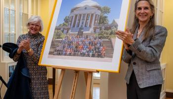 Two alumnae from the Class of '74 flank an unveiled portrait of the first class of undergraduate women to graduate from UVA.