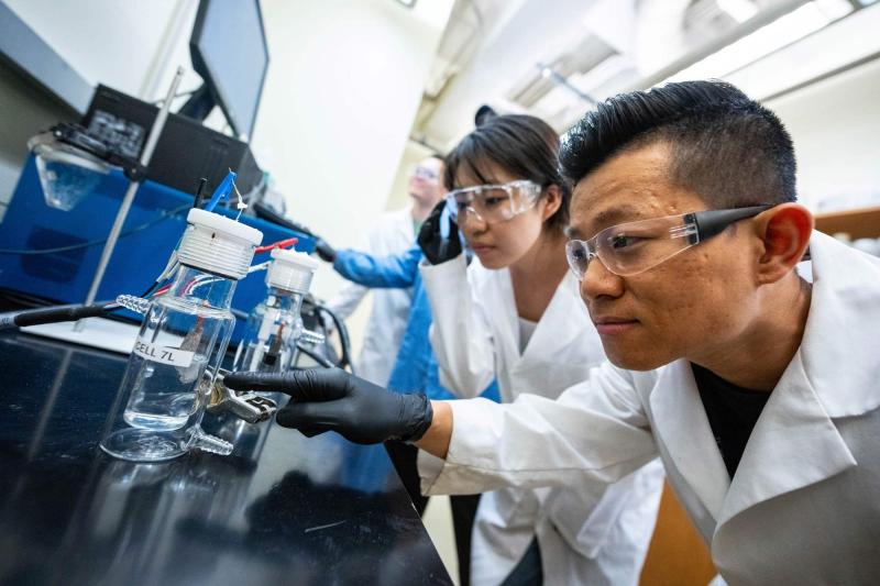 Students Liyue Zhang and Shen-Wei Yu, foreground, lean in for a closer look in a UVA lab aiming to make hydrogen energy a viable alternative. 