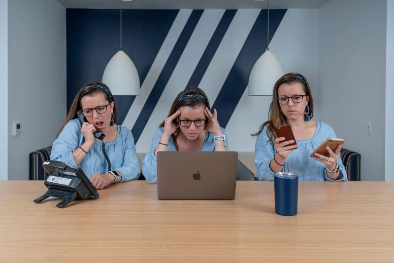 Woman multi-tasking with phone, computer and smartphones