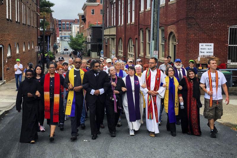 Local and national religious leaders and activists, including Rev. Osagyefo Uhuru Sekou, far left, and Cornel West, fourth from left, marched together on Aug. 12, 2017.