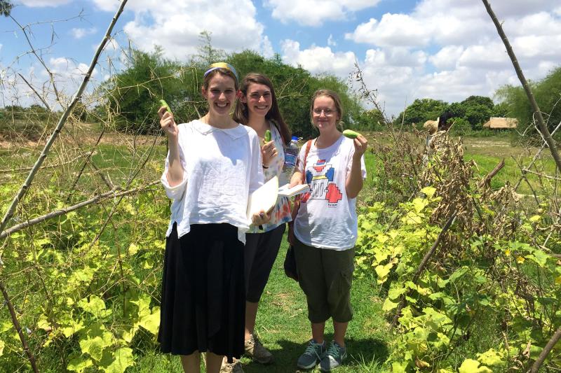 (Left to Right) Grace Muth, Emily Ewing and Amber Bouchard holding cucumbers grown during an experiment using Biochar, a environmentally-friendly soil amendment.