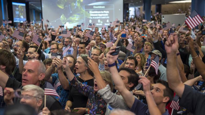Guests and New Horizons team members count down to the spacecraft’s closest approach to Pluto on July 14 at the Johns Hopkins University Applied Physics Laboratory. 