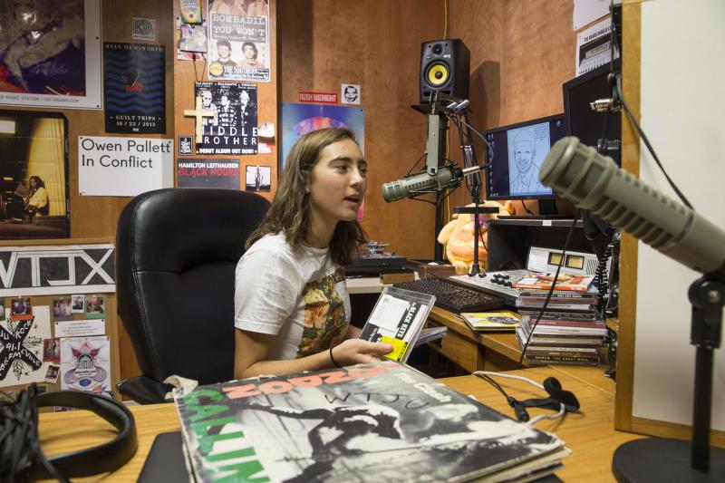 Helena Nicholaus, a student DJ for WXTJ, sits in front of the mixing boards at the WXTJ studio in Lambeth Commons.