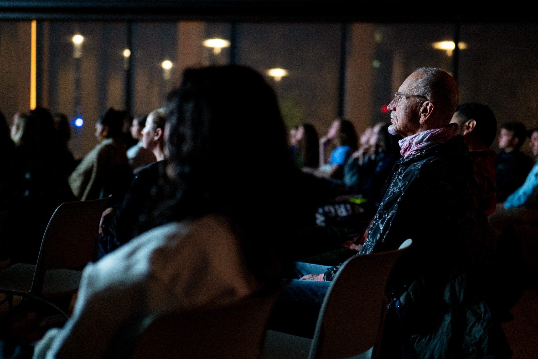 Close up photo of individuals watching a movie.