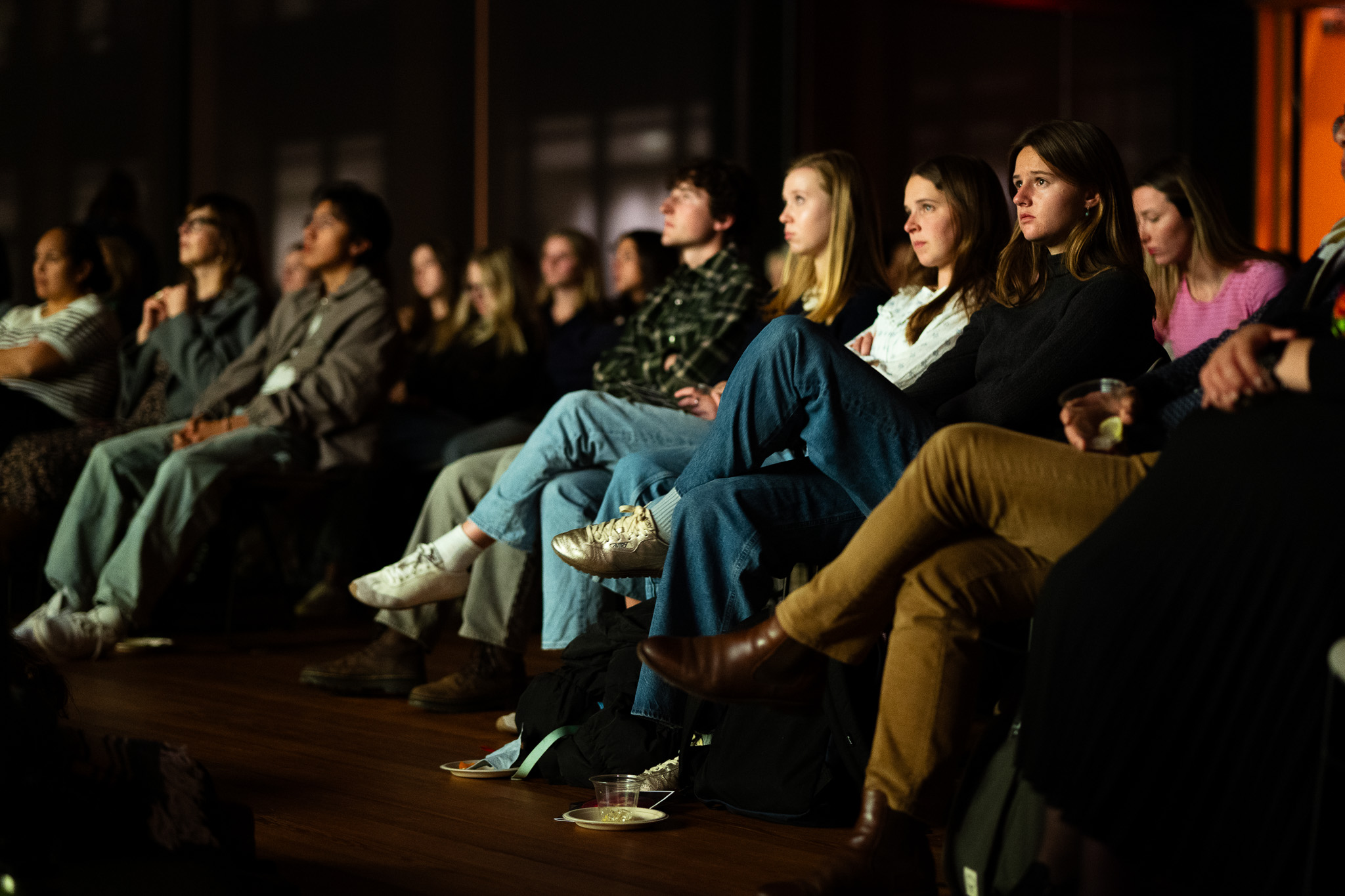 A row of audience members concentrate on a film screening.